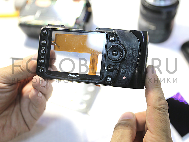 Инженер снял заднюю панель Nikon D90, чтобы заменить дисплей.